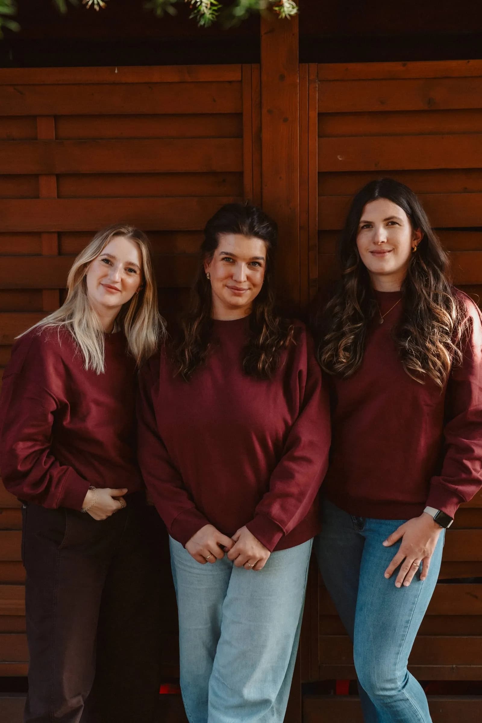Kimi, Melissa und Jessi vom muDDi Club vor einer Holzwand